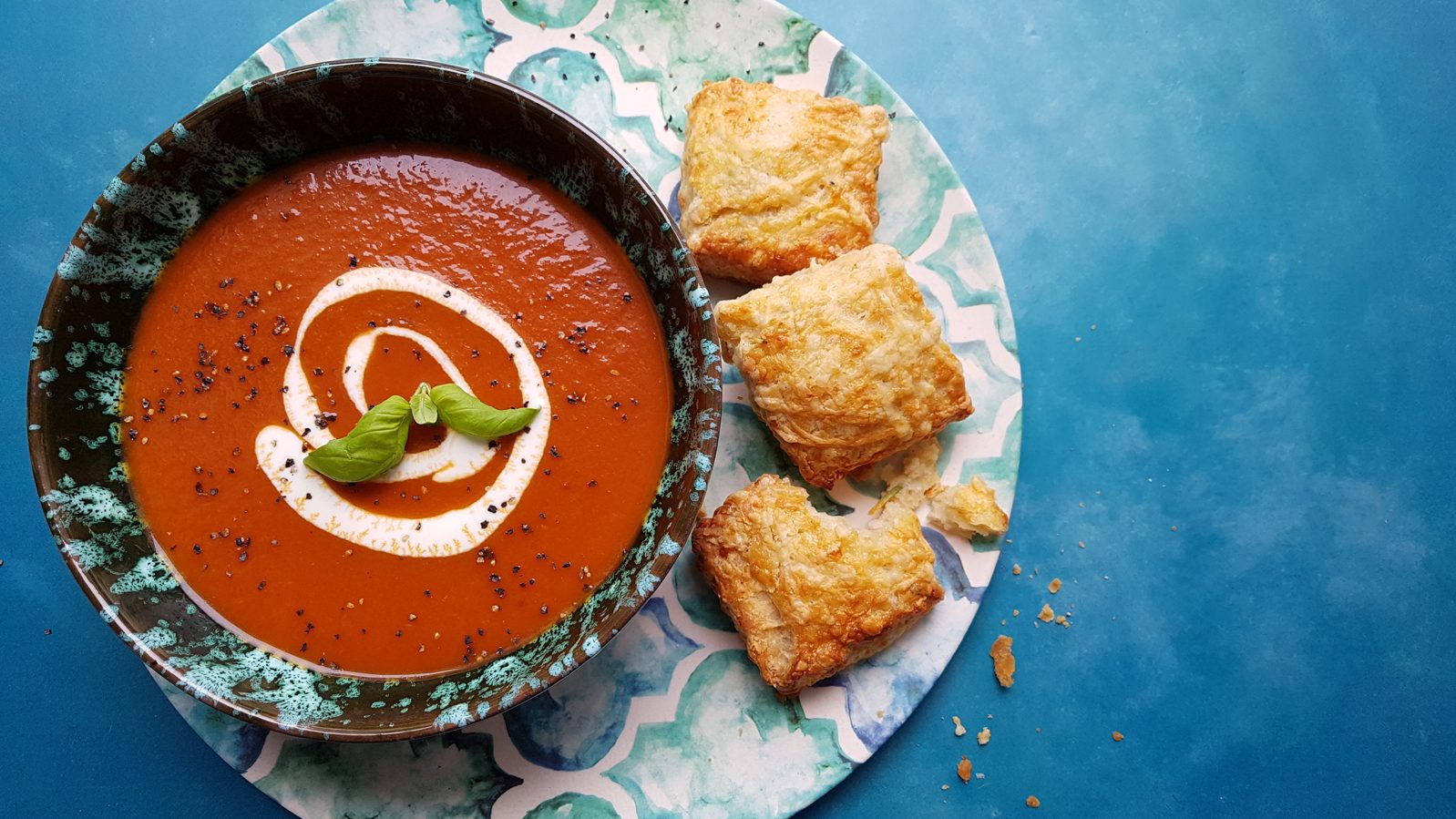 Tomato soup with cheese scones on a brightly patterned plate