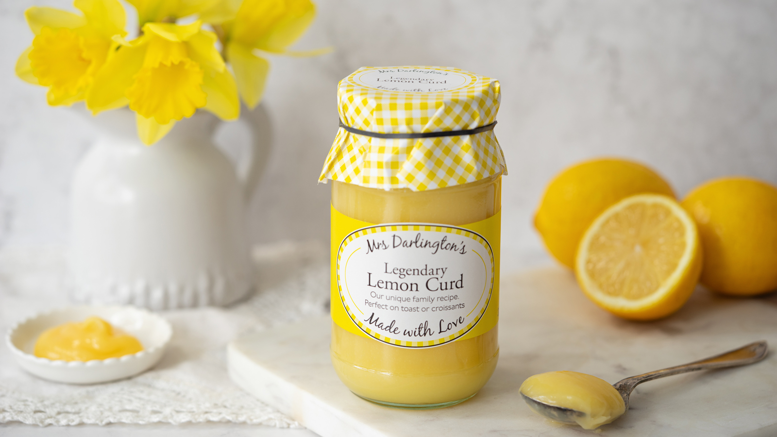 jar of lemon curd with fresh lemons and daffodils